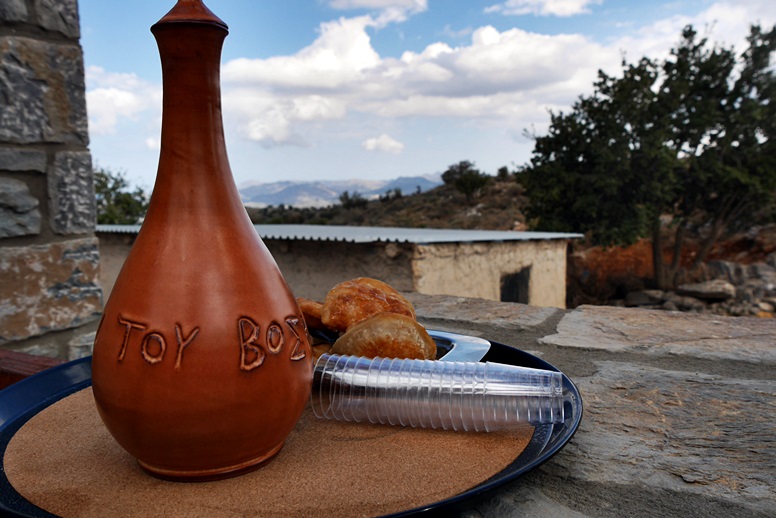 Tsikoudia Flasche im Hintergrund die Berge Kretas