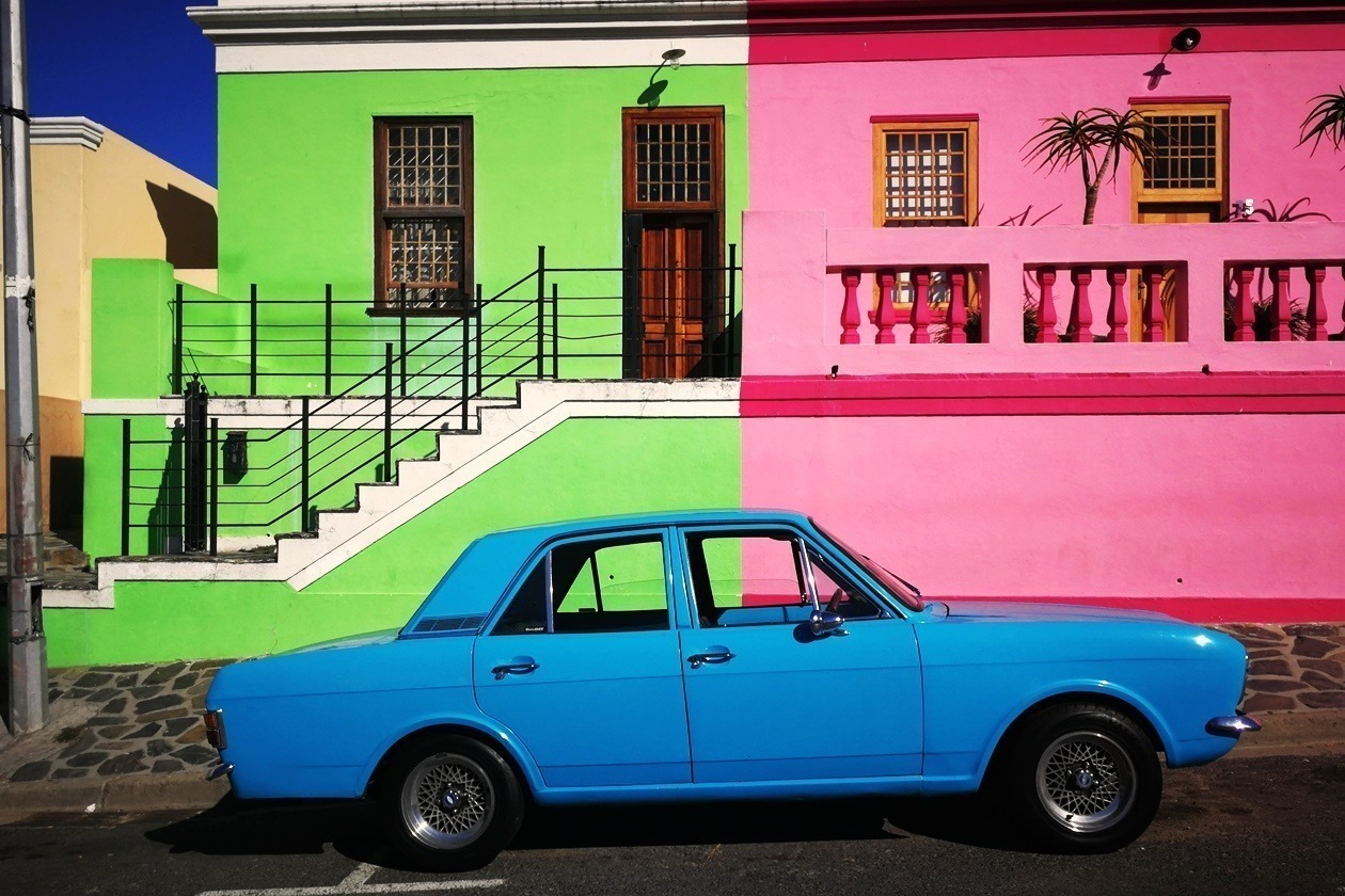 Blaues Auto vor den bunten Häusern des Bo-Kaap in Kapstadt