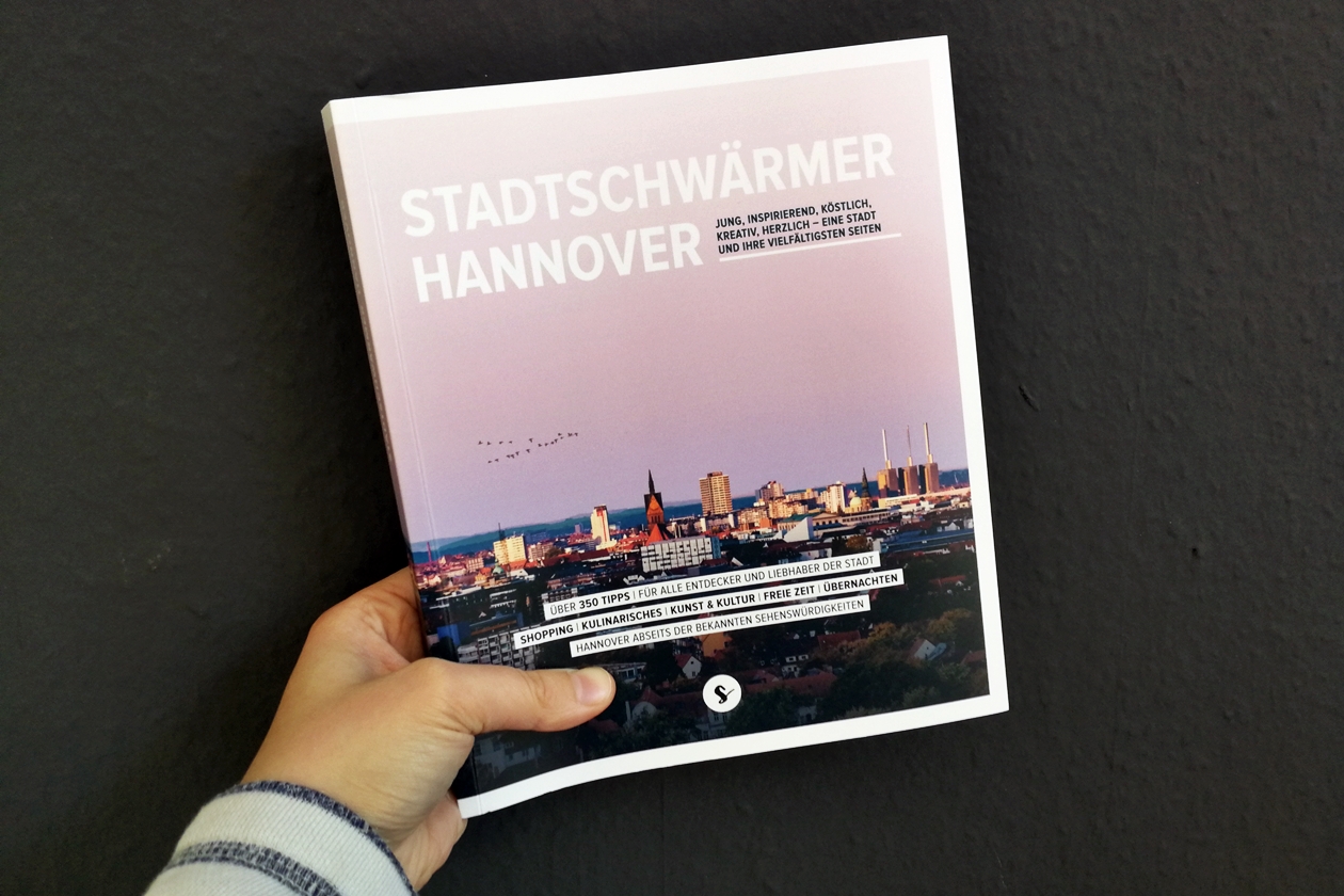 Hand mit dem Buch Stadtschwärmer Hannover