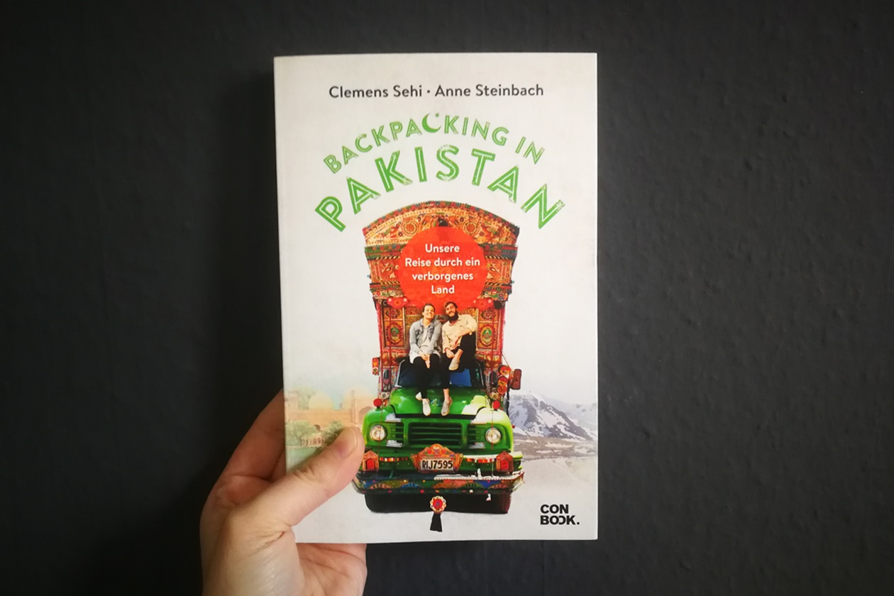 Hand mit dem Buch Backpacking in Pakistan