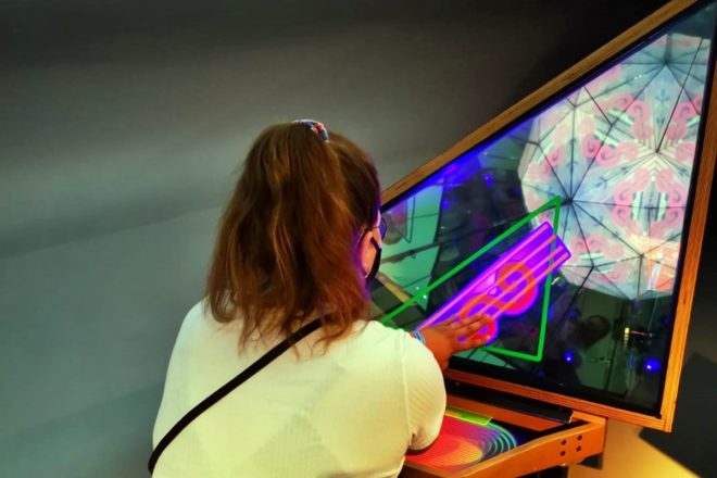 Frau an einem der 350 Experimente die man bei einem Besuch im phaeno Wolfsburg erleben kann