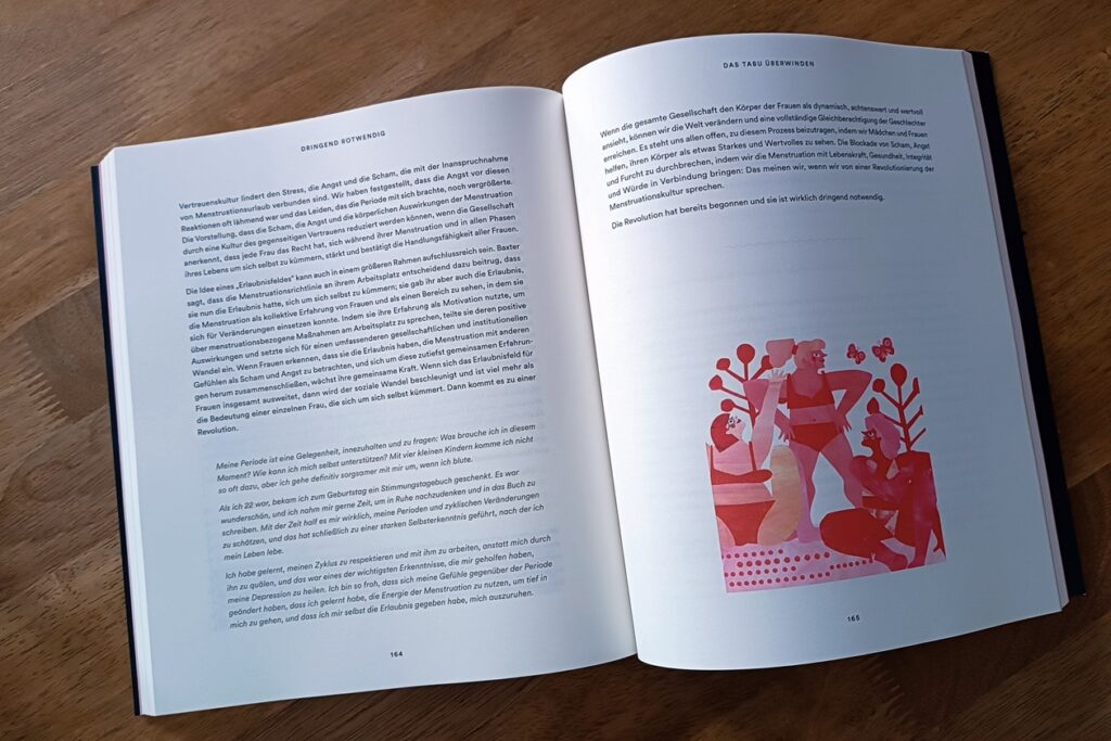 Das Buch "Dringend rotwendig - die menstruelle Revolution" liegt aufgeschlagen auf einem braunen Tisch. Links ist viel Text, rechts ist eine in rot gehaltene Grafik zu sehen. Auf dieser sind drei Frauen, Bäume und Schmetterlinge abgebildet.