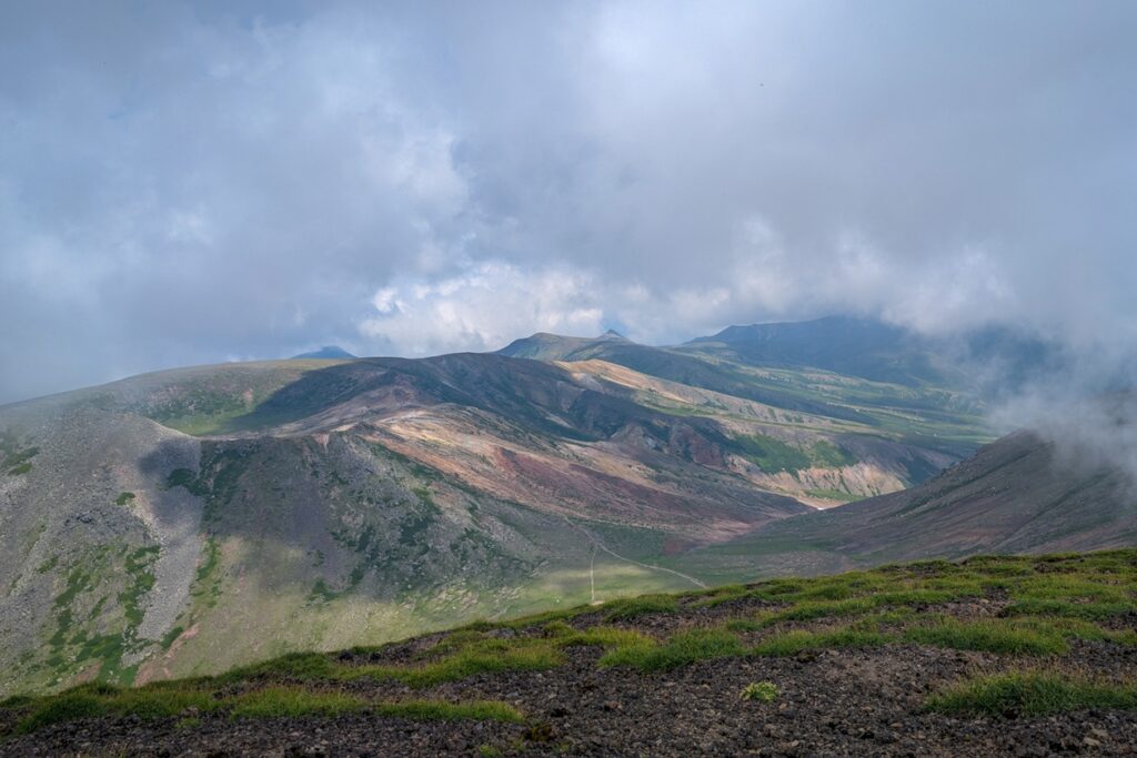 Blick vom Gipfel des Mt. Asahidake auf die umliegenden Vulkane. Sie hängen teilweise in den Wolken.