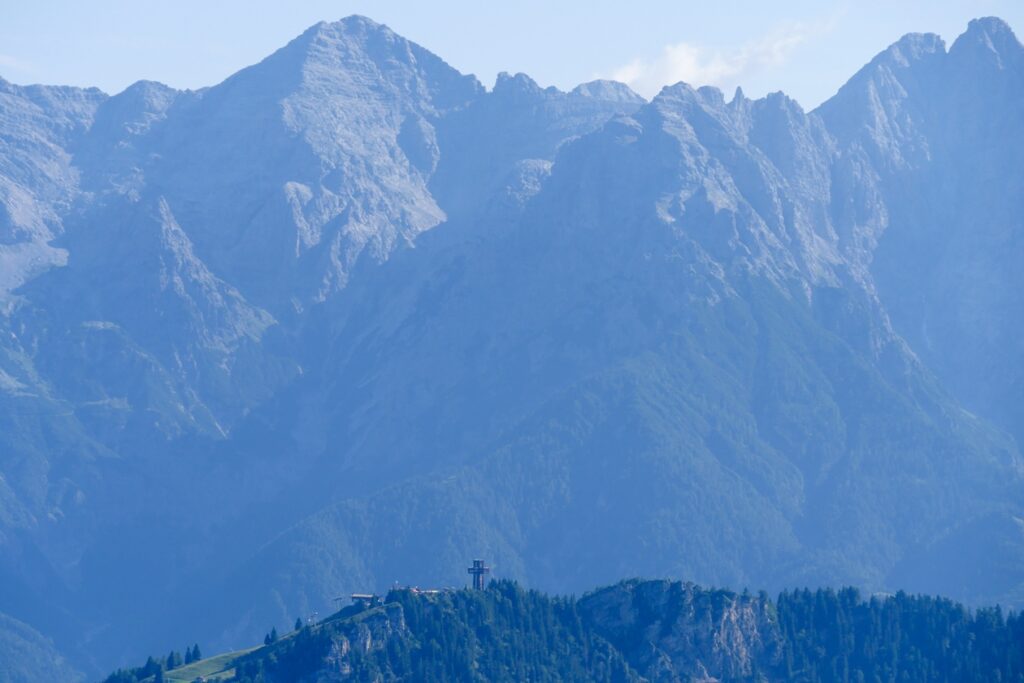 Blick auf das Jakobuskreuz in der Ferne. Im Hintergrund sind hohe Gipfel zu sehen.